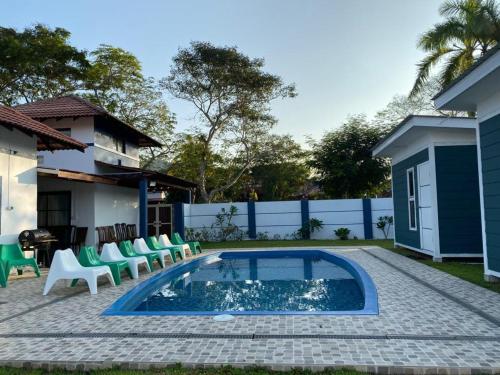 a backyard with a pool and chairs and a house at lot 1217 large private villa with pool A’Famosa golf resort melayu in Kampong Alor Gajah