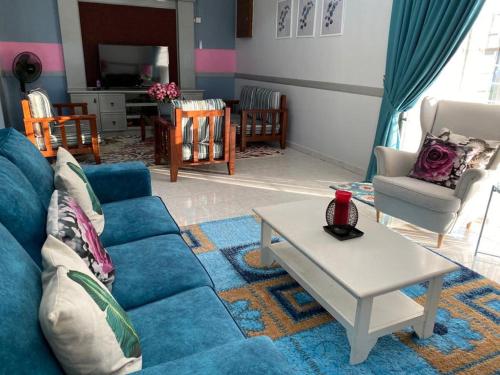 een woonkamer met een blauwe bank en een tafel bij lot 1217 large private villa with pool A’Famosa golf resort melayu in Kampong Alor Gajah