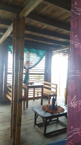 a room with a table and a bench in a house at La Cabaña in Montañita