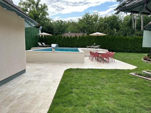 a backyard with a table and chairs and a pool at Elite House in Palić