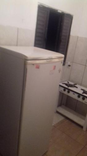 a small kitchen with a refrigerator and a stove at camping toca raul in São Thomé das Letras