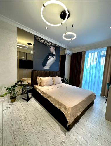 een slaapkamer met een bed en een schilderij aan de muur bij Luxury City-Centric Apartment for Booking in Chişinău