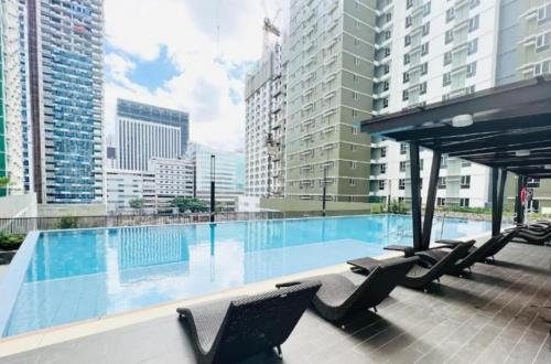 een zwembad met ligstoelen in een gebouw bij Cebu City Scape at Cebu IT Park in Cebu City