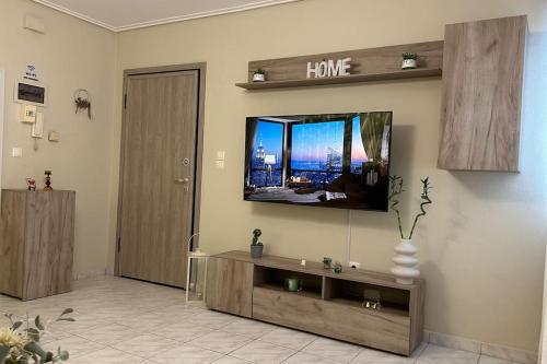 sala de estar con TV de pantalla plana en la pared en Central Modern Apartment Volos ll, en Volos