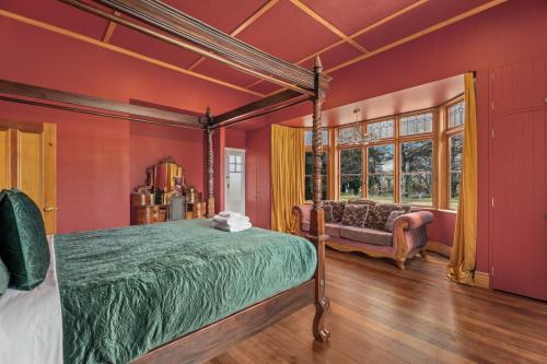 a bedroom with red walls and a bed and a couch at Glendhu Station Homestead - Glendhu Bay Home in Glendhu