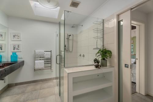 La salle de bains est pourvue d'une douche en verre et d'un lavabo. dans l'établissement Glendhu Station Homestead - Glendhu Bay Home, à Glendhu