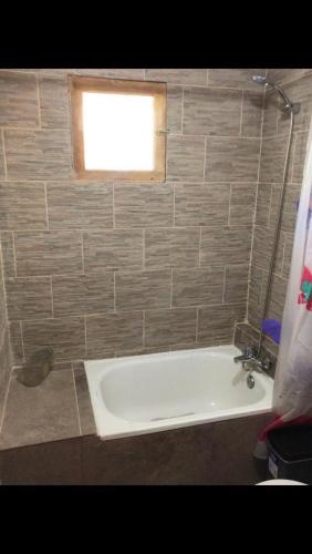 a bath tub in a bathroom with a window at Cabaña de Campo tulahuen in Piedra Lisa