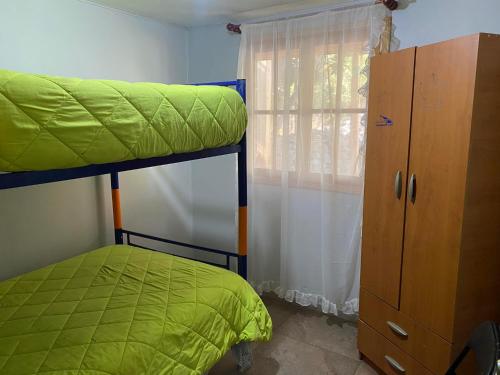 a bedroom with a bunk bed and a window at Cabaña de Campo tulahuen in Piedra Lisa
