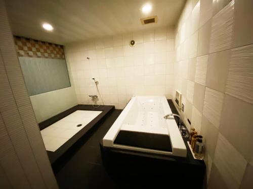 a bathroom with a sink and a bath tub at YOL in Saijo