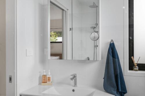 a bathroom with a sink and a mirror at Coastal Retreat in Kioloa