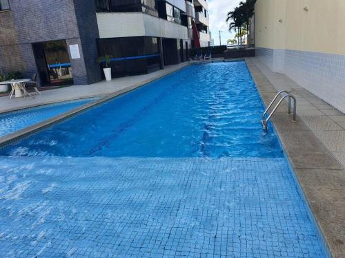 uma grande piscina azul num edifício em Maravilhosa cobertura duplex vista mar em Salvador