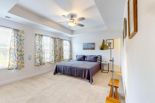 um quarto com uma cama e uma ventoinha de tecto em Daisy Place em Charleston