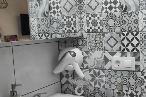 a tiled bathroom with a doll sitting on a toilet at EL RINCON DE SEVILLA a 9 min. del centro en Metro in San Juan de Aznalfarache