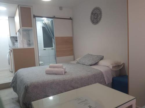 サン・ファン・デ・アスナルファラチェにあるEL RINCON DE SEVILLA a 9 min. del centro en Metroのベッド2台と鏡のある小さな寝室