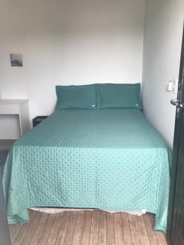 カンポ・グランデにあるHouse Dora AP 2 C AR CONDICIONADOのベッドルームに緑の掛け布団付きのベッド1台