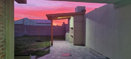 a sunset is seen through an opening in a building at Complejo Boulevard Plottier in Plottier