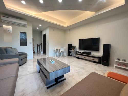 ein Wohnzimmer mit einem Sofa und einem Flachbild-TV in der Unterkunft Fay Homestay in Yilan