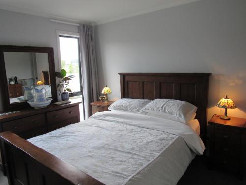 a bedroom with a large bed and a mirror at Llun y Mynydd B&B Nelson in Nelson