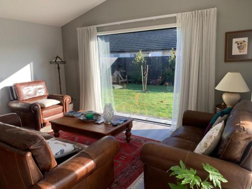 uma sala de estar com mobiliário de couro e uma grande janela em Llun y Mynydd B&B Nelson em Nelson