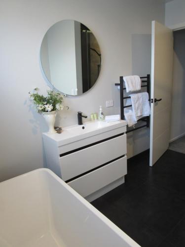 uma casa de banho com um lavatório branco e um espelho. em Llun y Mynydd B&B Nelson em Nelson