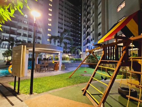 a park with a playground in a city at night at SM Spring Residences Tower 2 Condominium Bicutan Parañaque Cozy Condo in Manila