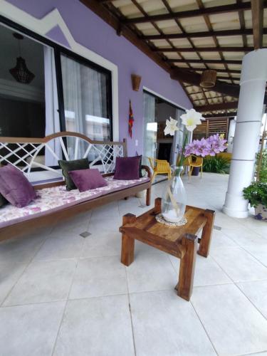 a porch with two benches and a vase on a table at Suite Fogo - A Casa 9 Lilás em Barra de Jacuipe in Camaçari