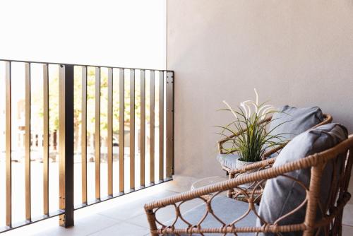 a balcony with a wrought iron fence and a plant at Urban Rest Port Adelaide Apartments in Port Adelaide