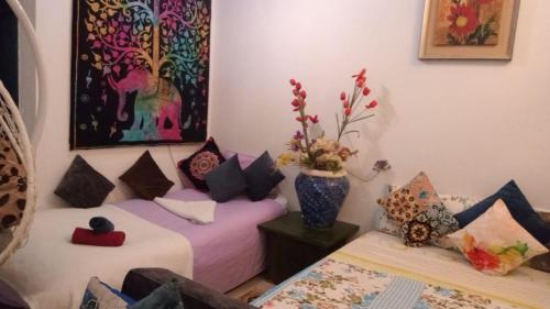 Cette chambre comprend 2 lits et un vase de fleurs. dans l'établissement Studio, à Dahab