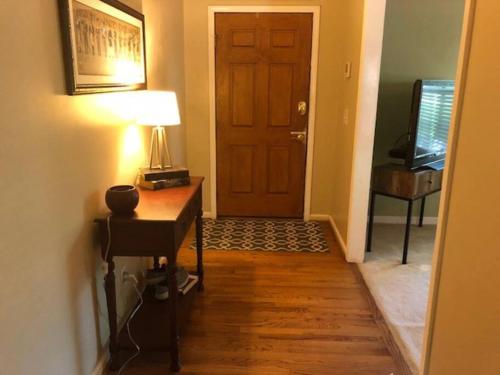 a hallway with a door and a table and a lamp at Quiet Kennesaw 3BR home - close to KSU, Lakepoint in Kennesaw