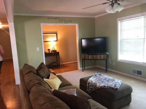 a living room with a couch and a flat screen tv at Quiet Kennesaw 3BR home - close to KSU, Lakepoint in Kennesaw