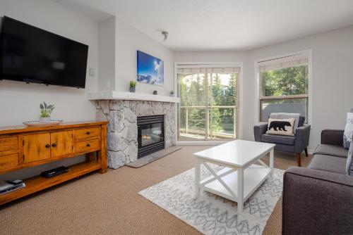 a living room with a tv and a fireplace at 1BR in The Aspens, King Bed, True Ski In, Ski Out, Hot Tubs and Pool, Ski Valet, Private Balcony in Whistler