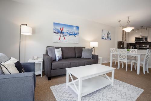 a living room with a couch and a table at 1BR in The Aspens, King Bed, True Ski In, Ski Out, Hot Tubs and Pool, Ski Valet, Private Balcony in Whistler