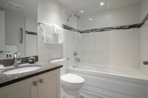 La salle de bains est pourvue de toilettes, d'un lavabo et d'une douche. dans l'établissement 1BR condo with ski-in and ski-out access by Harmony Whistler, à Whistler