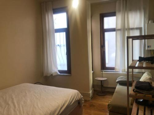 a bedroom with a bed and two windows at Taksim Cihangir Apartment Luxury in Beyoglu