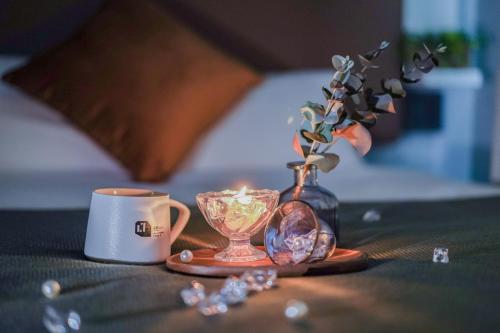 a table with a coffee cup and a vase with a candle at Apartment Hotel 11 Umeda in Osaka