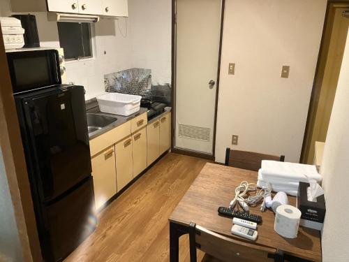 cocina con mesa y nevera negra en Nishimoto Building - Vacation STAY 34362v, en Hiroshima