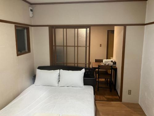 1 dormitorio con cama, escritorio y mesa en Nishimoto Building - Vacation STAY 34362v, en Hiroshima