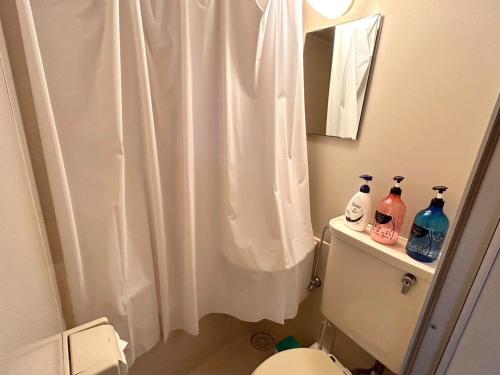 a bathroom with a white shower curtain and a toilet at Nishimoto Building - Vacation STAY 16010v in Hiroshima