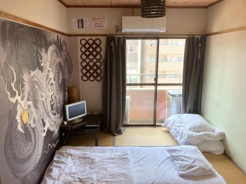 um quarto com duas camas e uma televisão e uma janela em Nishimoto Building - Vacation STAY 16012v em Hiroshima