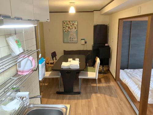 um pequeno quarto com uma mesa e uma cama em Nishimoto Building - Vacation STAY 93789v em Hiroshima