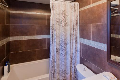 uma casa de banho com uma banheira e uma cortina de chuveiro em The Comfort Stay at City of Pickering em Pickering