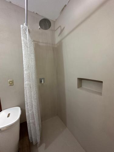 a bathroom with a shower curtain and a toilet at Hotel Atelie del Mar in Monterrico