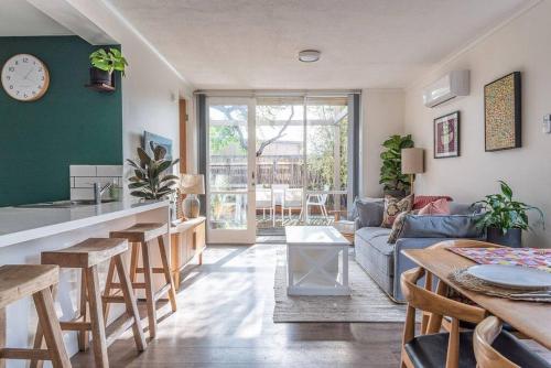a kitchen and living room with a couch and a table at Cosy Corner Hideaway in Torquay