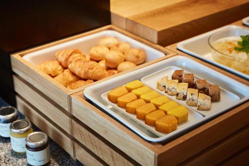 a table with two trays filled with different types of food at MUJI HOTEL GINZA in Tokyo