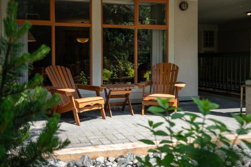 two chairs and a table on a patio at Convenient Village Location with Pool and Hot Tub in Whistler