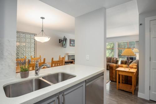 a kitchen with a sink and a living room at Convenient Village Location with Pool and Hot Tub in Whistler