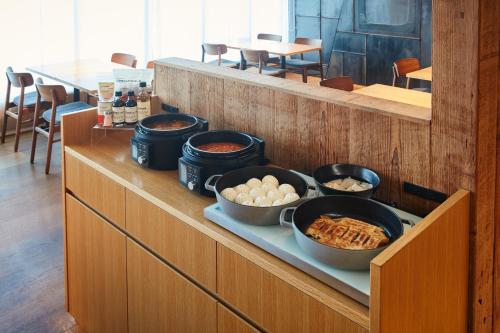 a buffet with bowls of food on a counter at MUJI HOTEL GINZA in Tokyo