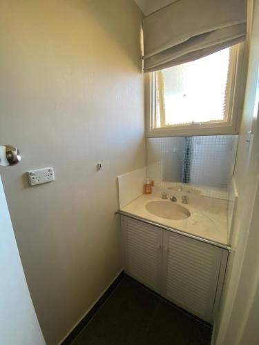a bathroom with a sink and a window at Doncaster Westfield Home Stay in Doncaster