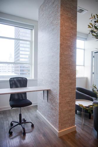 an office with a brick wall and a desk and a chair at Stylish Downtown High-Rise - 2BD in Baton Rouge