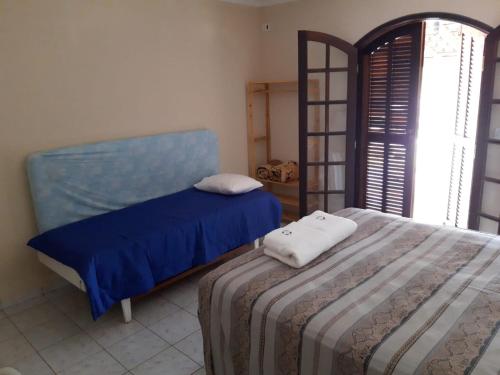 a bedroom with a bed with blue sheets and a shelf at Giardino Mediterraneo in São Pedro